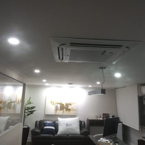 Unidade de ar-condicionado tipo cassete embutida no teto de uma sala comercial